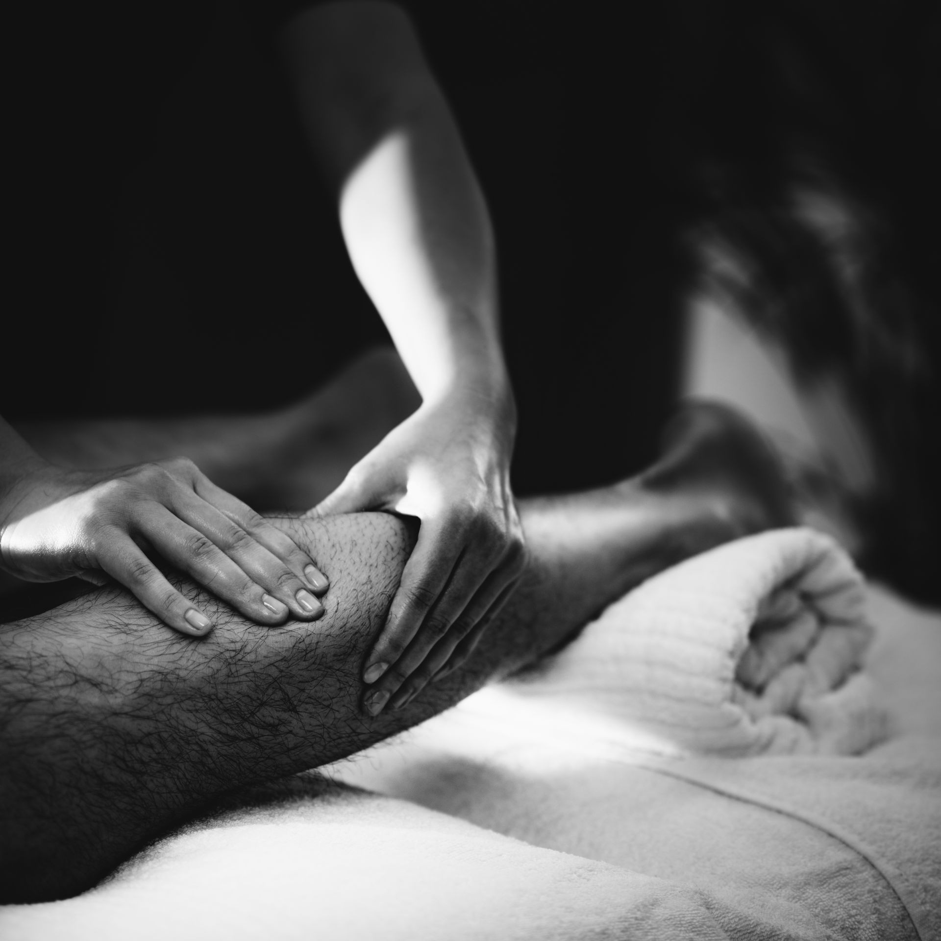 Physiotherapist massaging male patient with injured leg - calf muscle. Sports injury treatment.